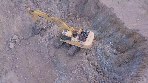 The drone is filming an excavator from different angles that is in the pit. 库存影片 119016942