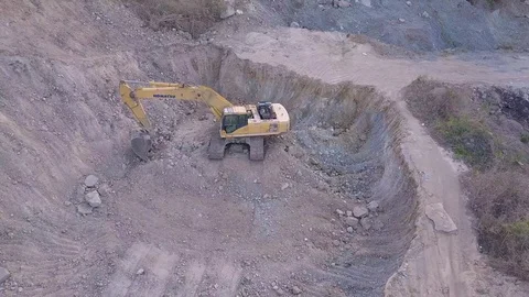 The drone is filming an excavator from different angles that is in the pit. Stock Footage 119017145