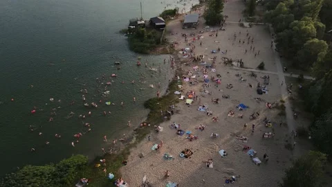 Drone filming a sandy beach crowded with people by the lake. Stock Footage 157729243