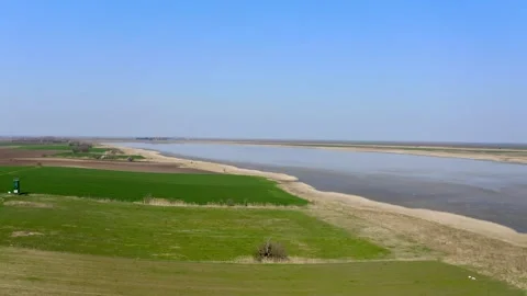 Drone flies above green fields surrounding a lake in nature reserve Slano Kopovo Stock Footage 270501886