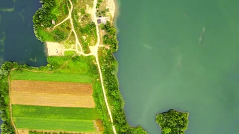 Drone flies above land separating two lakes with woods, roads, beach and houses Stock Footage 269164495