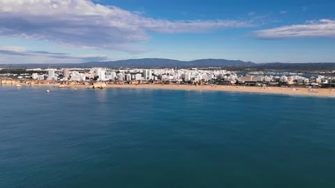 Drone flies above the water towards Praia da Rocha beach and Portimao town Stock Footage 292999197