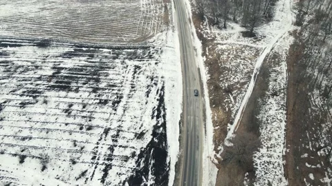 The drone flies after the car that drives on the road in winter Video stock 149954591