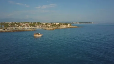 The drone flies after the ship, in the background the coastline. Side view of Stock-Footage 93296570