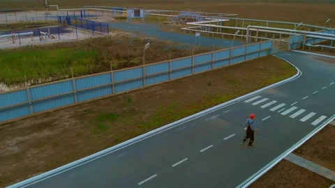 A drone flies after a worker in a helmet running along the road to urgently stop Stock Footage 167416185
