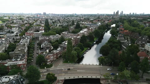 Drone flies along the canal capturing the densely built-up area in Amsterdam Stock Footage 255184845