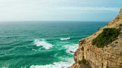 Drone flies along mountain towards  ocean shore during Summer sunny day. Ae.. Stock Footage 328738154