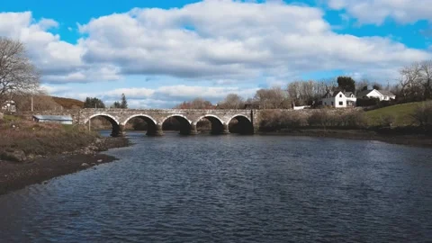 The drone flies along the river to the old footbridge in Ireland Stock Footage 234111418