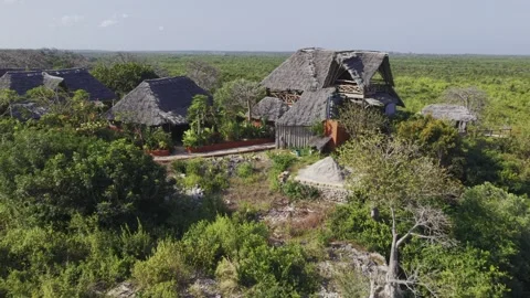 Drone flies up and over hilltop resort deep in forest on a sunny afternoon Stock Footage 344105347