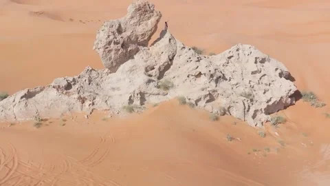 A drone flies around a bearded man dressed as a shaman who prays on a cliff in Stock Footage 242976370