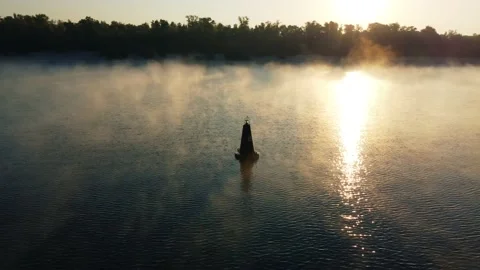 Drone flies around a buoy on the river, morning mist over the water, fog Stockbeeldmateriaal 186052016