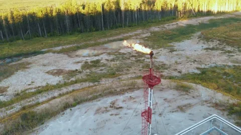 A drone flies around a burning torch at an oil field in the swamps of Siberia Stock Footage 151876728