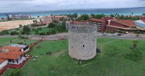 Drone flies around an old stone tower and green field. Bird's-eye view at city Stock Footage 65535046