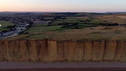 Drone flies back from cliff and beach in West Bay Stock Footage 94364490