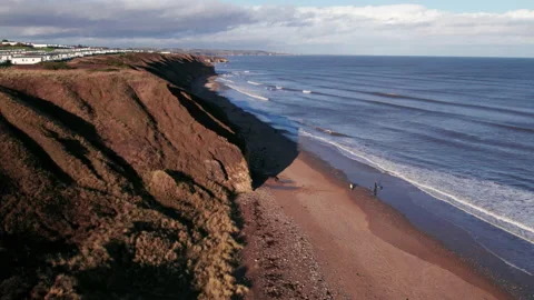 Drone flies back over beach and cliffs in County Durham Stock Footage 234187696
