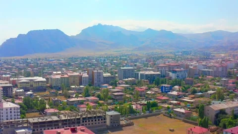 Drone flies backward above a city in eastern Turkey, revealing residential Vídeo Stock 344835650