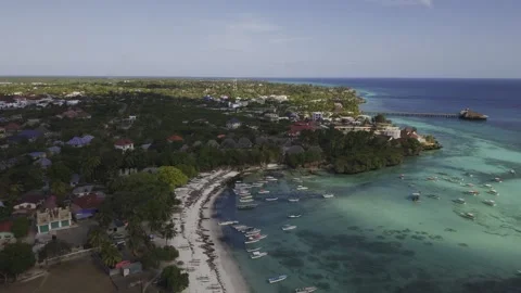 Drone flies backward over beach at high tide with fishing boats Stock-Footage 346484773