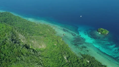 Drone flies backward over reef past small island, turning Stock-Footage 327475144