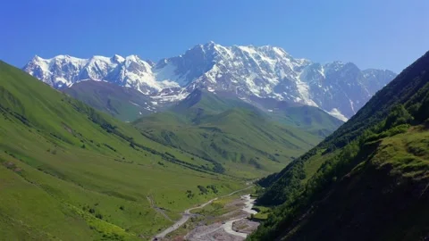 Drone flies backward from Shkhara massif above Enguri valley and green Caucasus Vídeo Stock 343543071