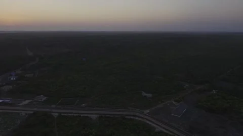 Drone flies backwards high over forest with new paved road to Mtende Beach Stock Footage 344166554