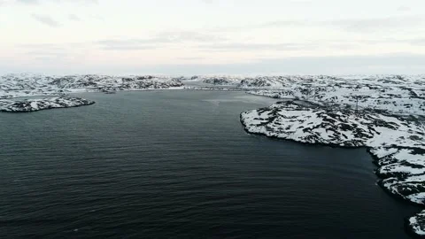 The drone flies in the bay of the Arctic Ocean to the rocky shores. The harsh Stock Footage 169464787