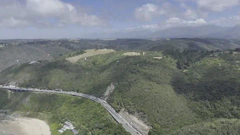 Drone flies from beach over coastal highway and over paragliders Stock Footage 326769772