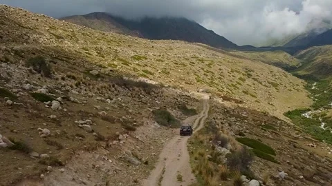 Drone: flies behind a car through a gorge in the mountains of Kyrgyzstan Video stock 266896185