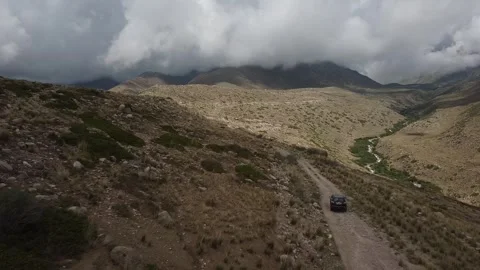 Drone: flies behind a car through a gorge in the mountains of Kyrgyzstan Video stock 266896502
