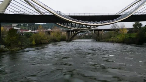 Drone flies below Millennium Bridge Miño River in Ourense, Galicia, Spain Stock Footage 259616608