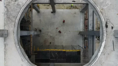 Drone flies from a circle whole on a floor at a construction site. Stock Footage 157292545