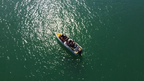 A drone flies close around a floating boat in the lagoon of a picturesque Stock Footage 147528454