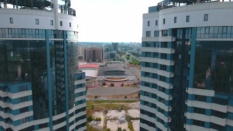 A drone flies dangerously through two skyscrapers Stock Footage 245004475