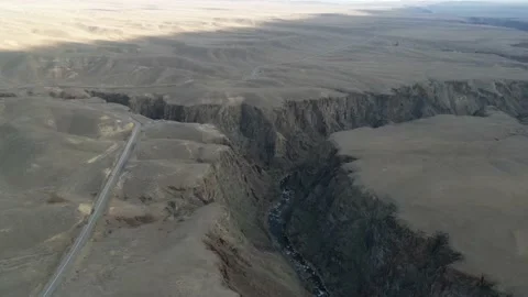 The drone flies deep into the canyon where you can see the river Stock Footage 227127866