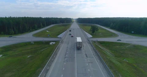 Drone Flies Directly Over Freeway. Over Forest Road. Trucks and Cars Driving Stock Footage 164644573
