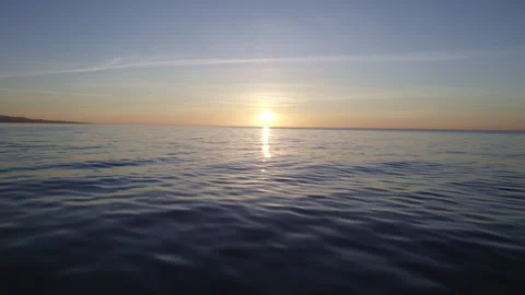 The drone flies directly into the setting sun over the sea Stock Footage 260112359
