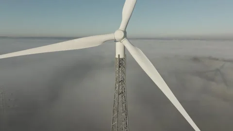 Drone flies down in front of rotating rotors of a wind turbine. Stock Footage 301292626