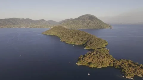 Drone flies east high over west side of Thumbi Island at sunset Stock Footage 337540251