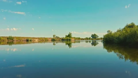 Drone flies extremely  closely to a river with a smooth water surface. Beauti Stock Footage 135916780