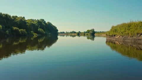 Drone flies extremely  closely to a river with a smooth water surface. Beauti Stock Footage 142562710