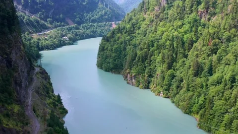 Drone flies forward above Enguri Reservoir through a deep forested gorge in Vídeo Stock 343543383