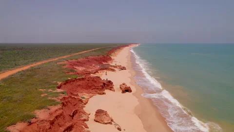 Drone flies forward along James Price Point, revealing dramatic red cliffs Stock Footage 324496180