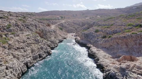 Drone flies forward between narrow rocky Volcanic canyon nature and blue sea. Stock-Footage 168254710