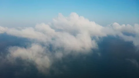 The drone flies forward high in the blue sky through the fluffy clouds Stock Footage 106380203