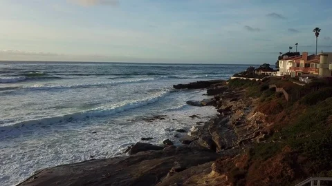 Drone flies forward over beach cliffs near oceanfront homes. Stock Footage 84774565