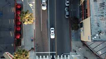 Drone flies forward over California beach town boulevard with camera facing down Stock Footage 86129792