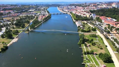 A drone flies forward over the Mondego River flowing through Coimbra City Stock Footage 202024207