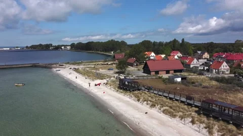 The drone flies forward over a sandy beach along the coastal buildings of Hel Vídeos de archivo 346078890