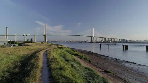 Drone flies forwards over Thames riverbank with QEII Bridge Stock Footage 92511308