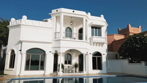 A drone flies in front of the facade of a luxury private villa with a swimming Stock Footage 310731618