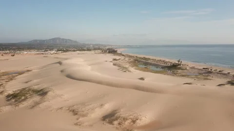 The drone flies going through the sand dunes towards the sea. Stock Footage 152550417